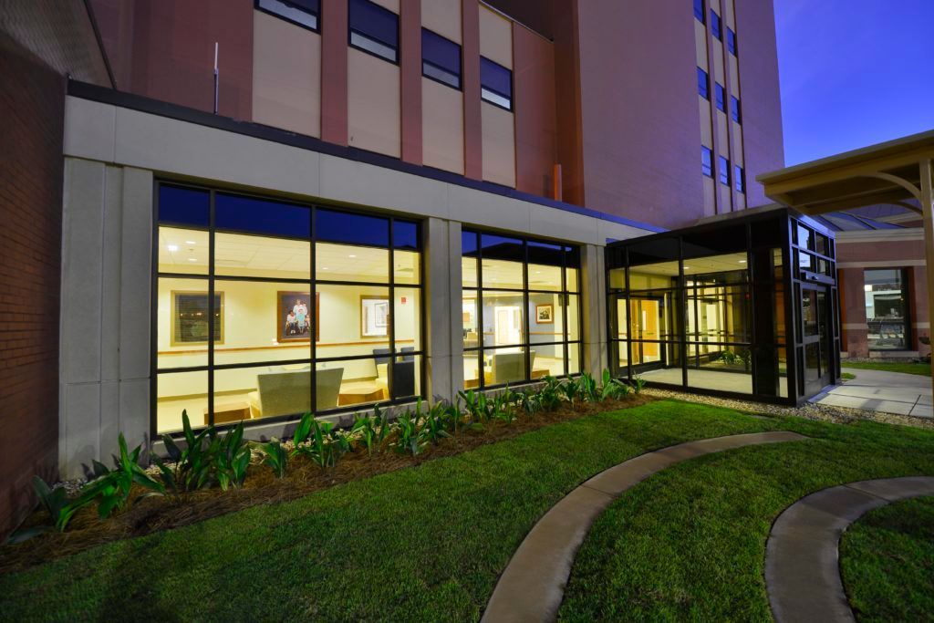 A large building with a lot of windows and a lawn in front of it