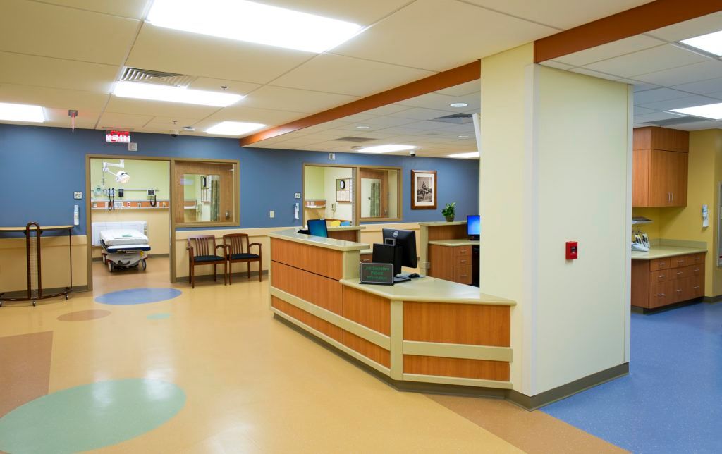 A hospital waiting room with a desk and chairs