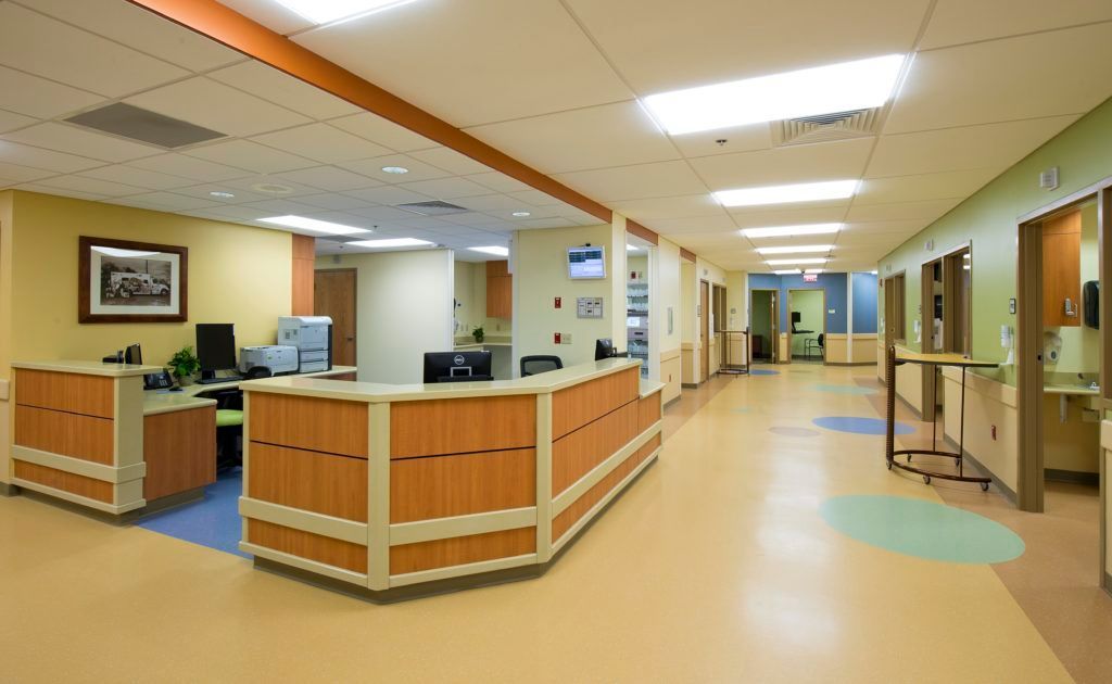 A hospital hallway with a reception desk in the middle