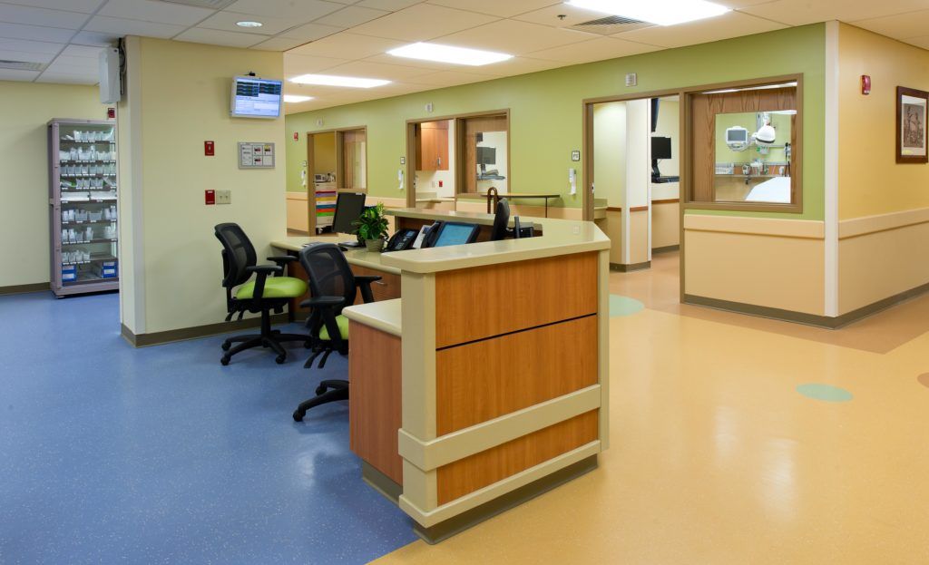 A hospital waiting room with a desk and chairs