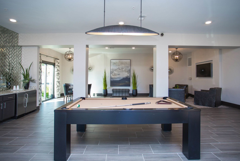 There is a pool table in the middle of the room.