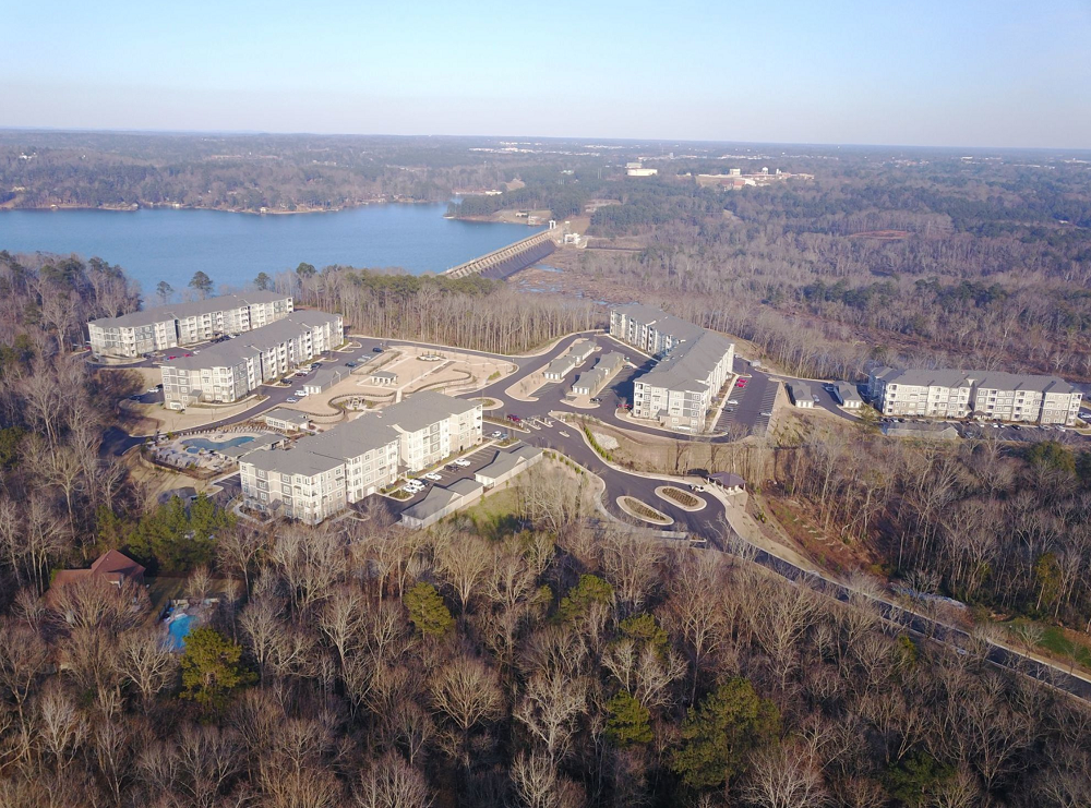 An aerial view of a residential area with a lake in the background.