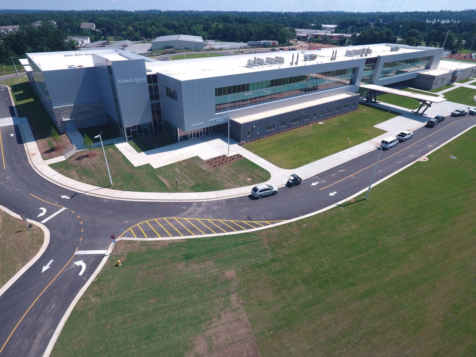 An aerial view of a large building with a white roof