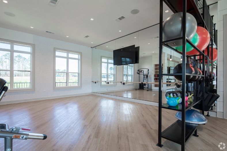 A gym with a lot of exercise equipment and a large mirror.