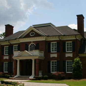 A large brick house with black shutters on the windows