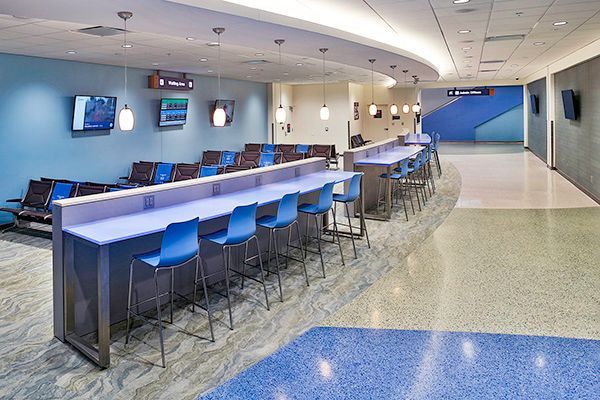 A waiting room with a long table and chairs.