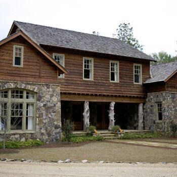 A large wooden and stone house with a gray roof