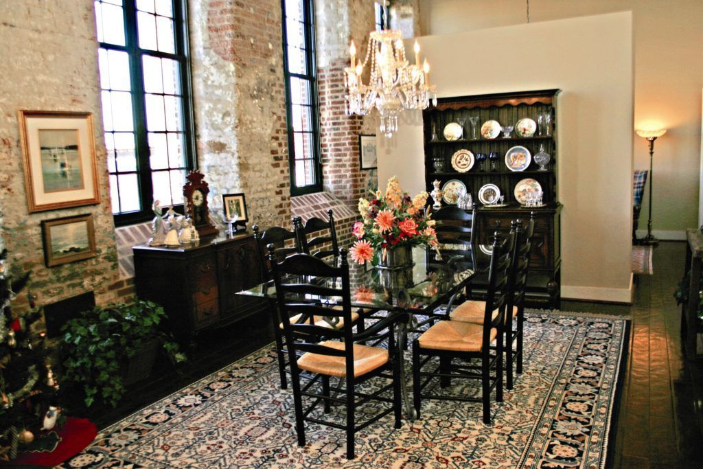 A dining room with a table and chairs and a rug