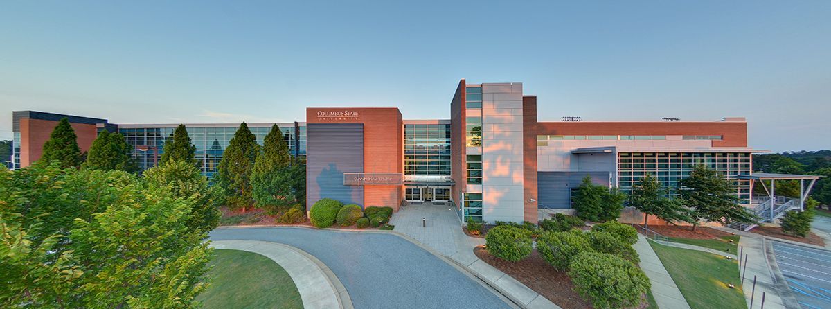 A large building with a lot of windows and trees in front of it.