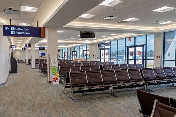 There are a lot of seats in the waiting area at the airport.