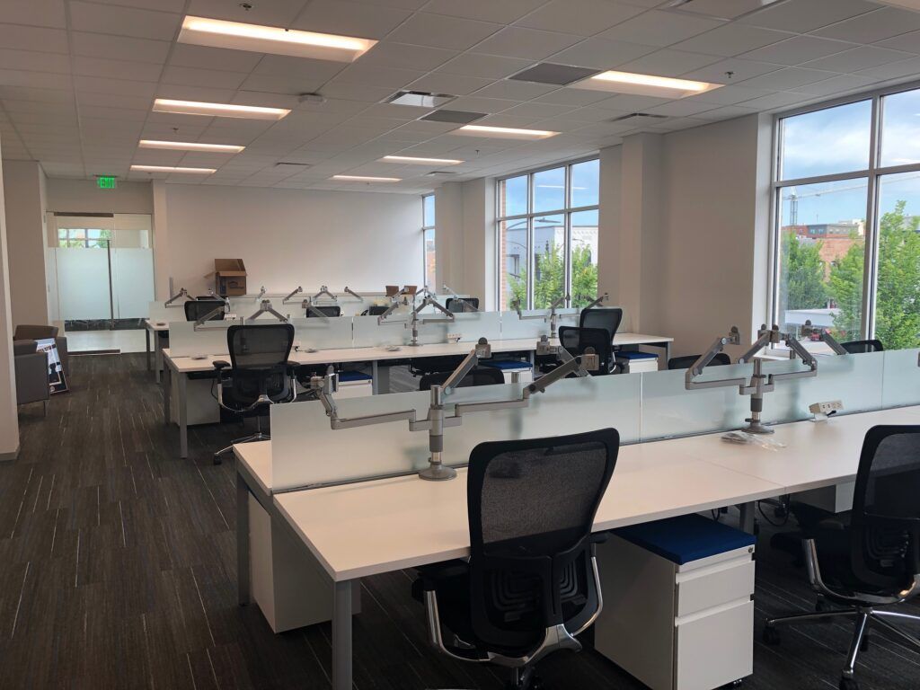 A large office with a lot of desks and chairs.