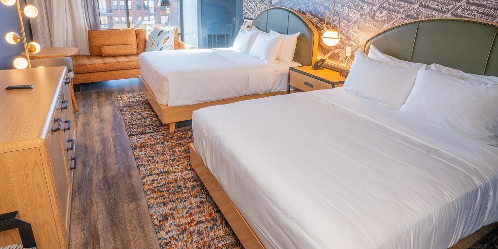 A hotel room with two beds and a couch.