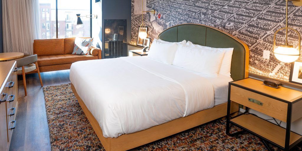 A hotel room with a king size bed and a couch.