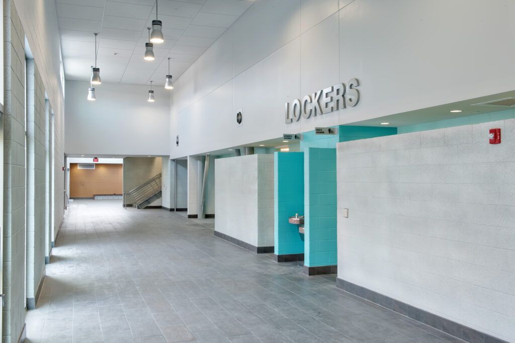 A long hallway with lockers written on the wall