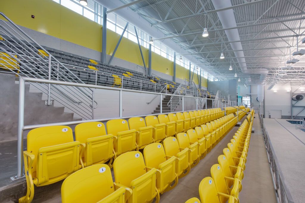 A row of yellow seats in an empty stadium.
