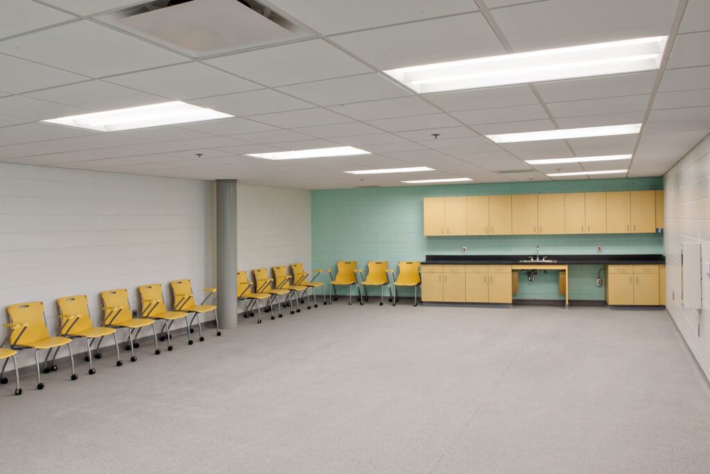 An empty room with a row of chairs and a table