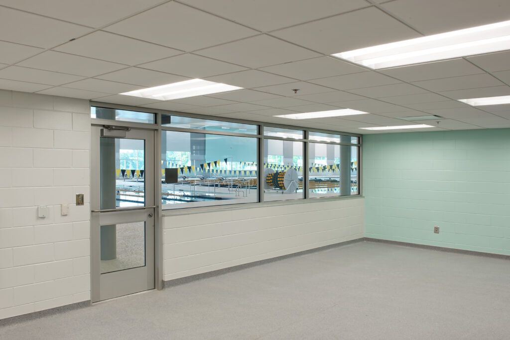 An empty room with a door and a lot of windows