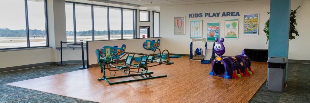 A large room with a lot of windows and a kids play area.