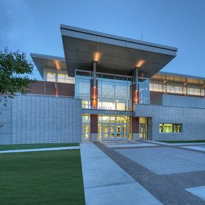 A large building with a lot of windows and a walkway leading to it.