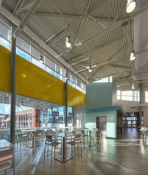 A large room with tables and chairs and a yellow wall