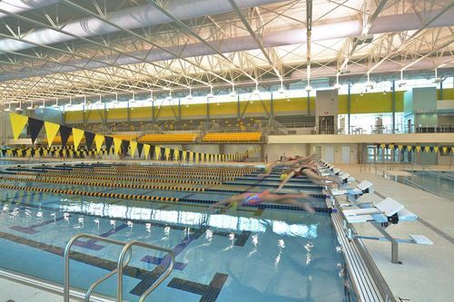 A large indoor swimming pool with yellow flags on the side