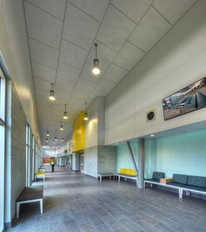 A long hallway with a lot of windows and benches in a building.
