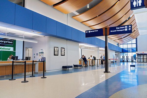 The inside of an airport with a national sign on the wall