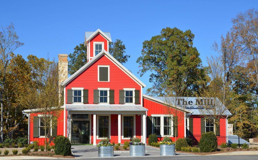 A large red barn with a sign that says the mill