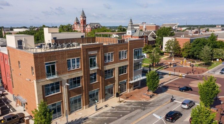 An aerial view of a brick building in the middle of a city.