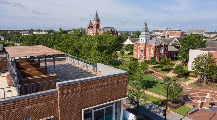 An aerial view of a city with a brick building in the foreground.