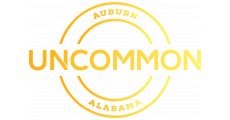 The logo for uncommon alabama is yellow and gold.