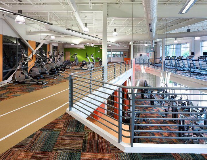 A large gym with a staircase leading to the second floor.