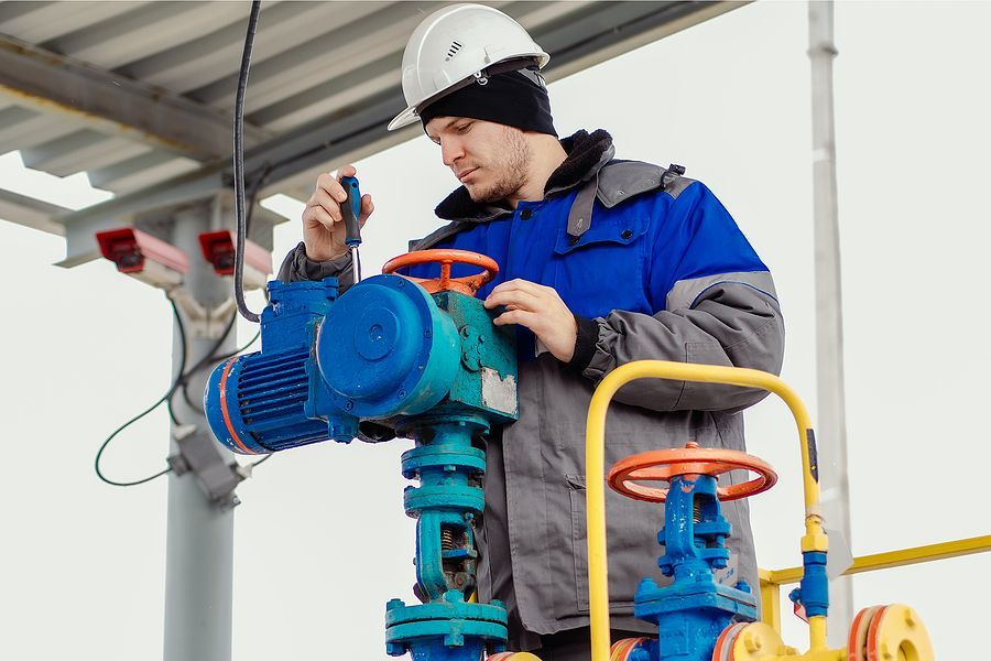 a man in a hard hat working on a pipe