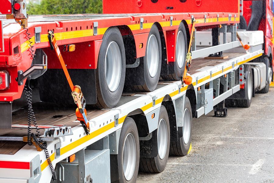 a semi truck with a flatbed trailer attached to it's flatbed