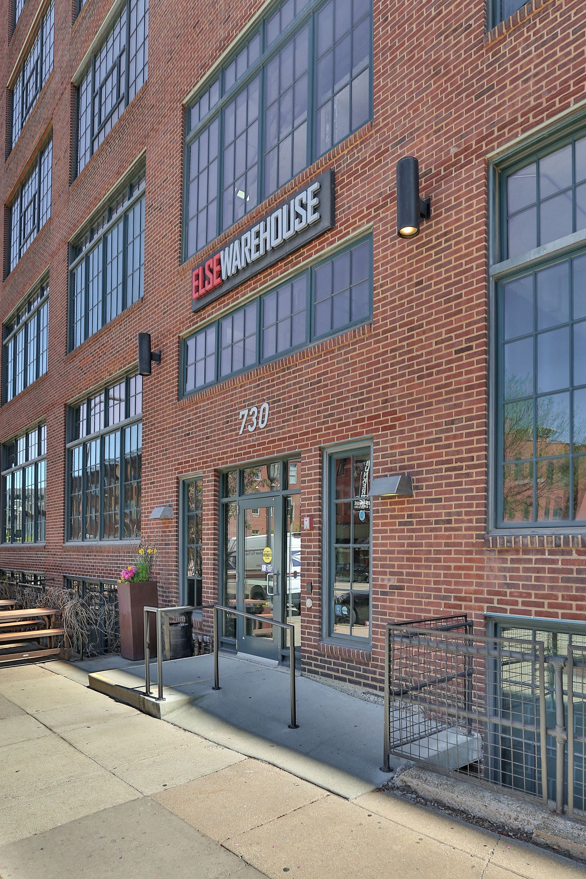 A large brick building with a lot of windows and a sign that says warehouse.