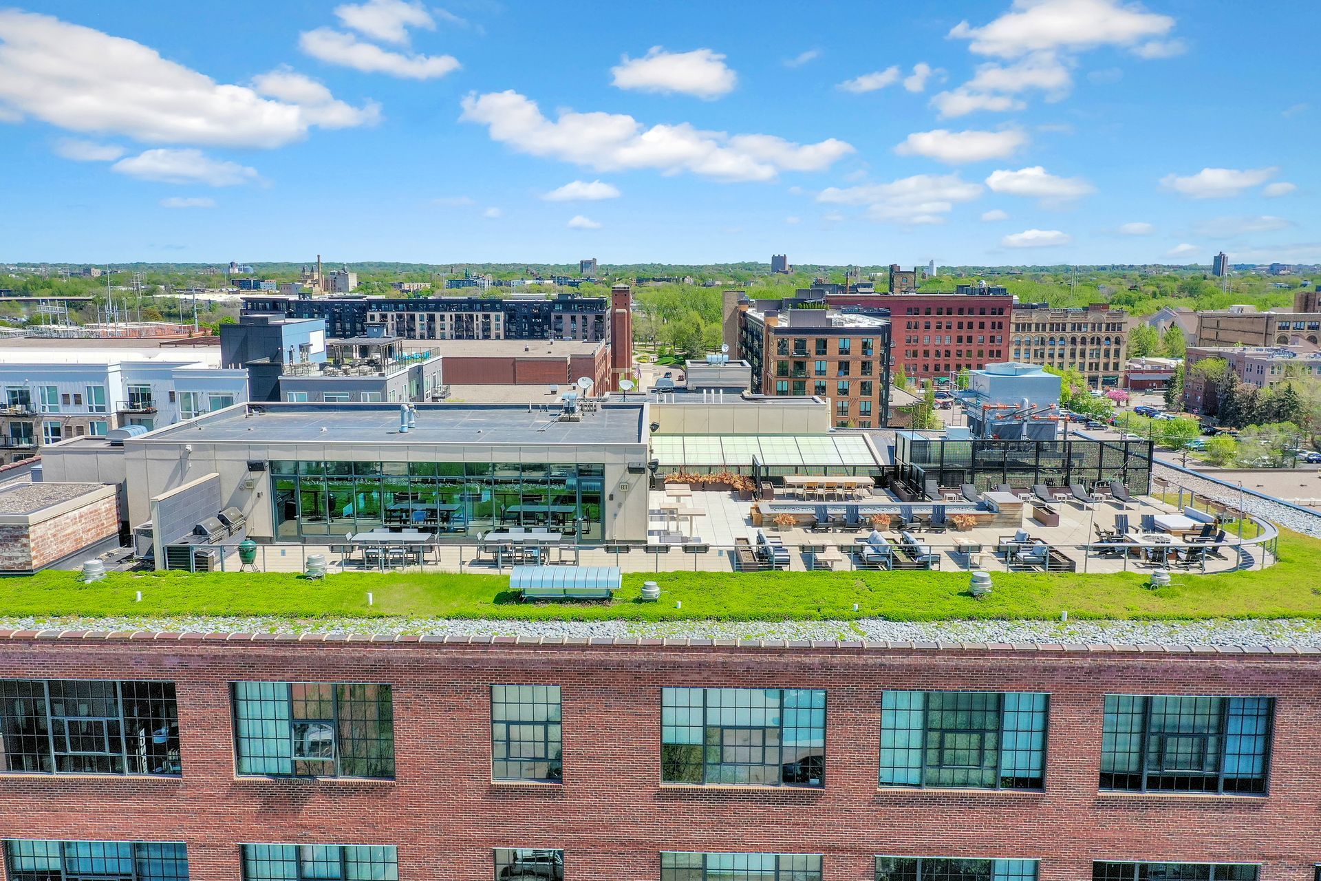 An aerial view of a brick building with a green roof.