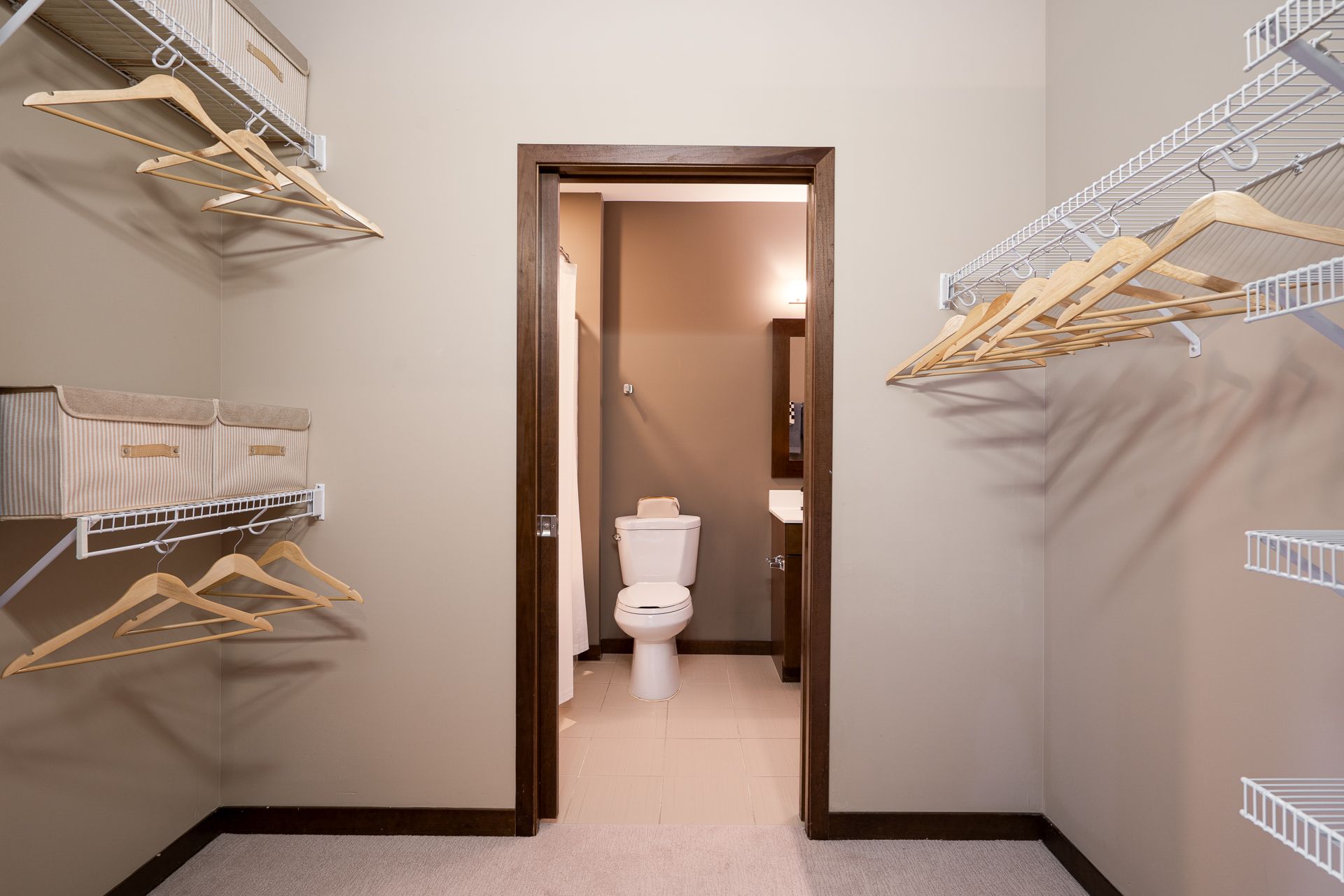 A walk in closet with a toilet and a bathroom.