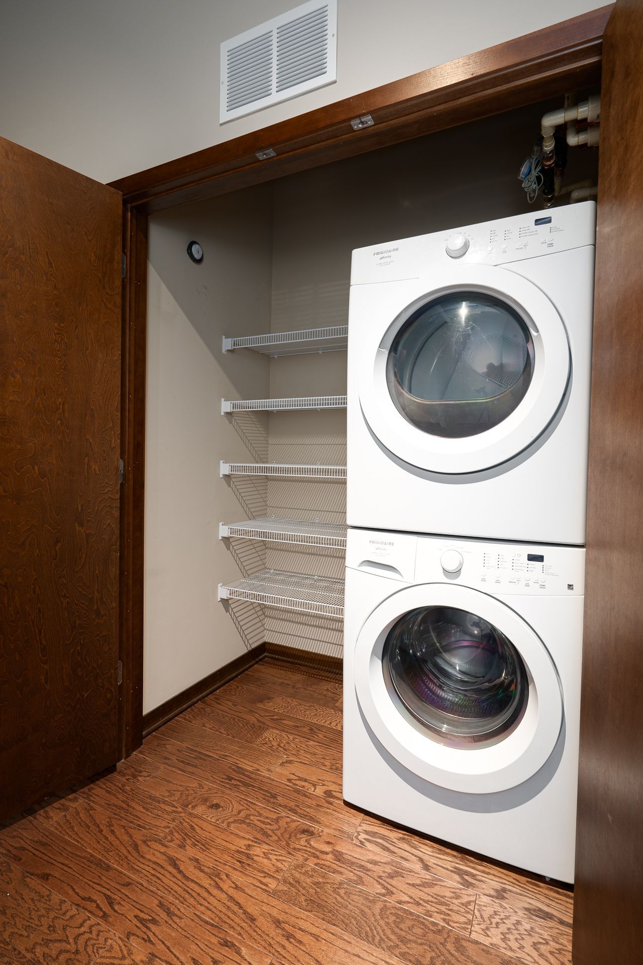 A washer and dryer are stacked on top of each other in a laundry room.