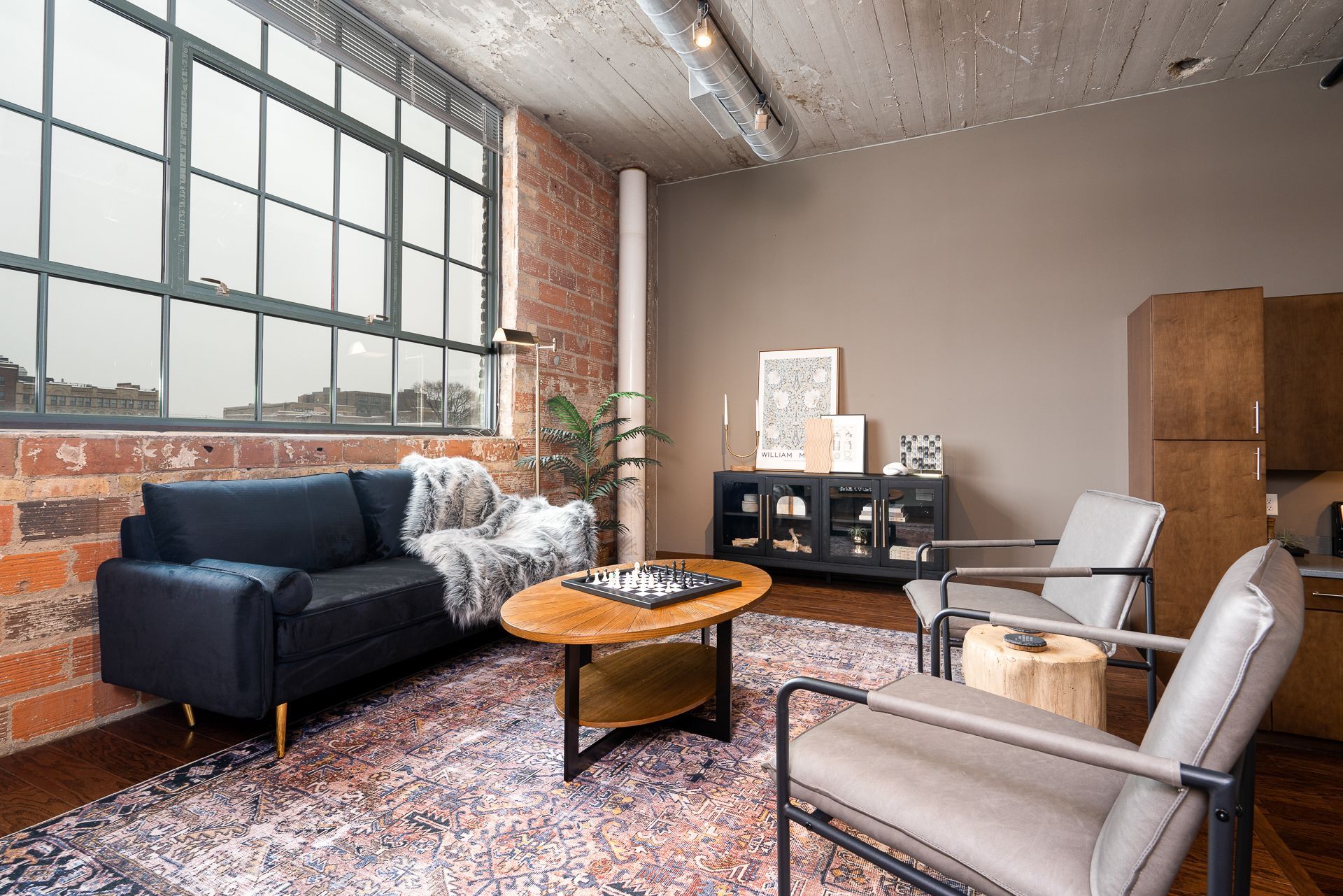 A living room with a couch , chairs , and a coffee table.