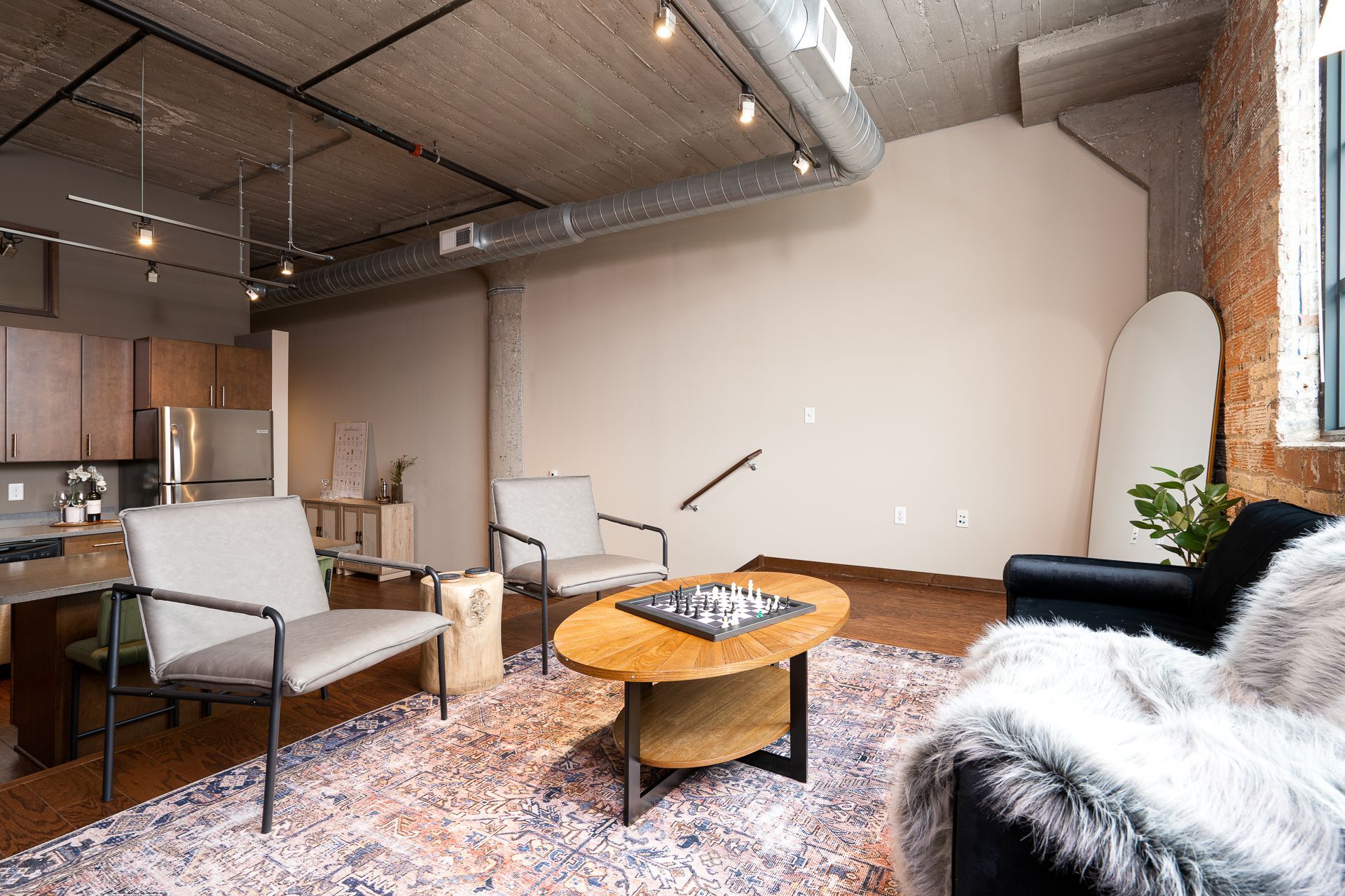 A living room with two chairs , a coffee table , and a rug.