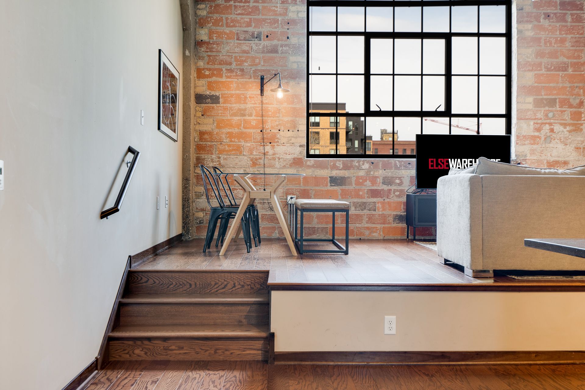 A living room with a brick wall and a large window
