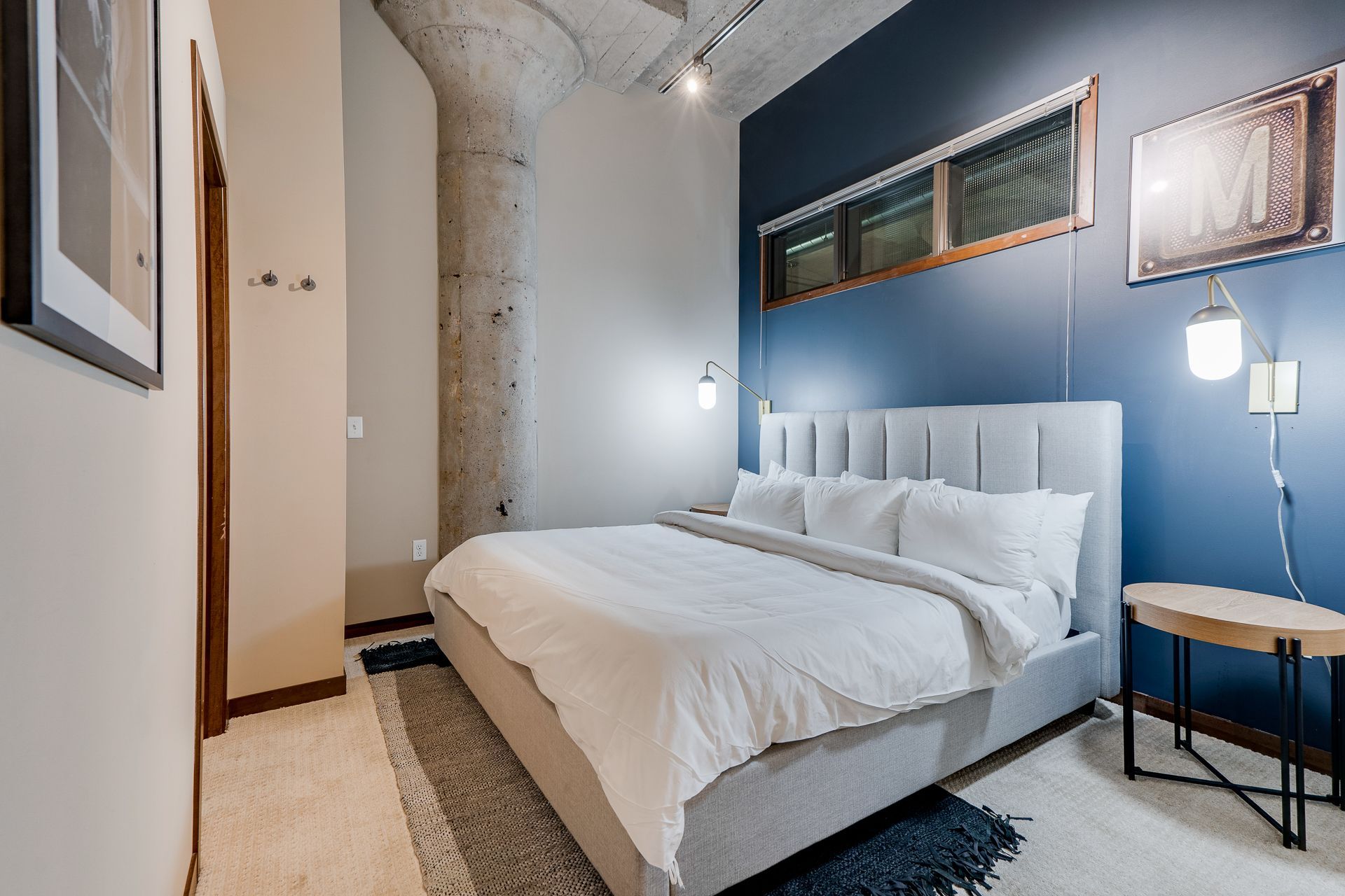 A bedroom with a large bed and a blue wall.