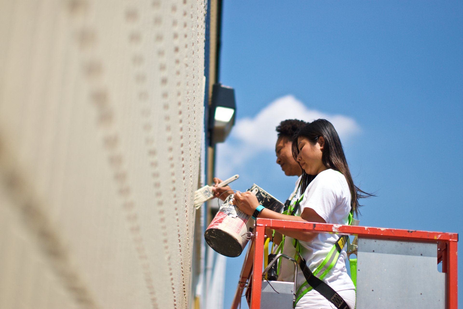 Photo of women painting exterior