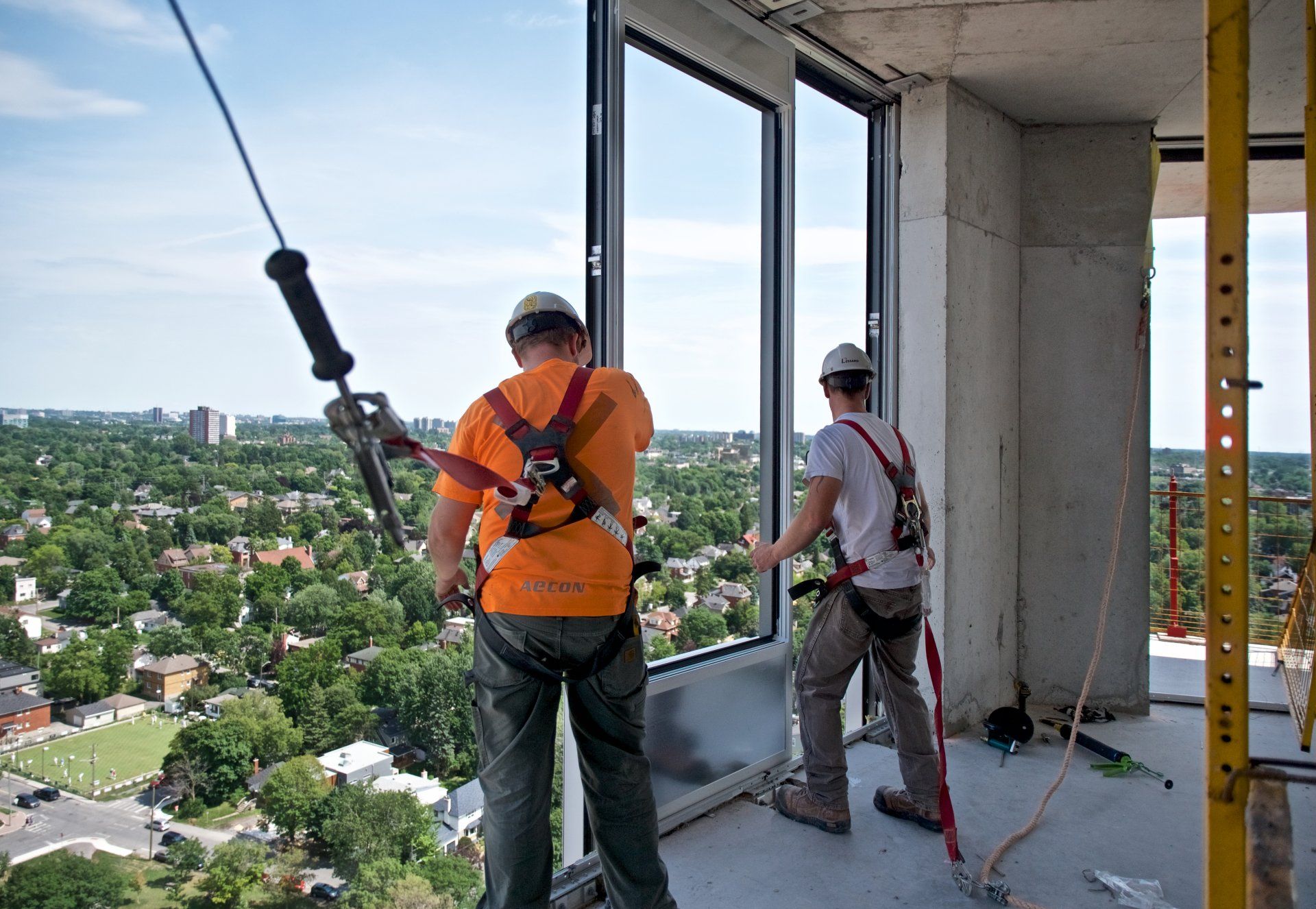 Photo of men setting a window in a building