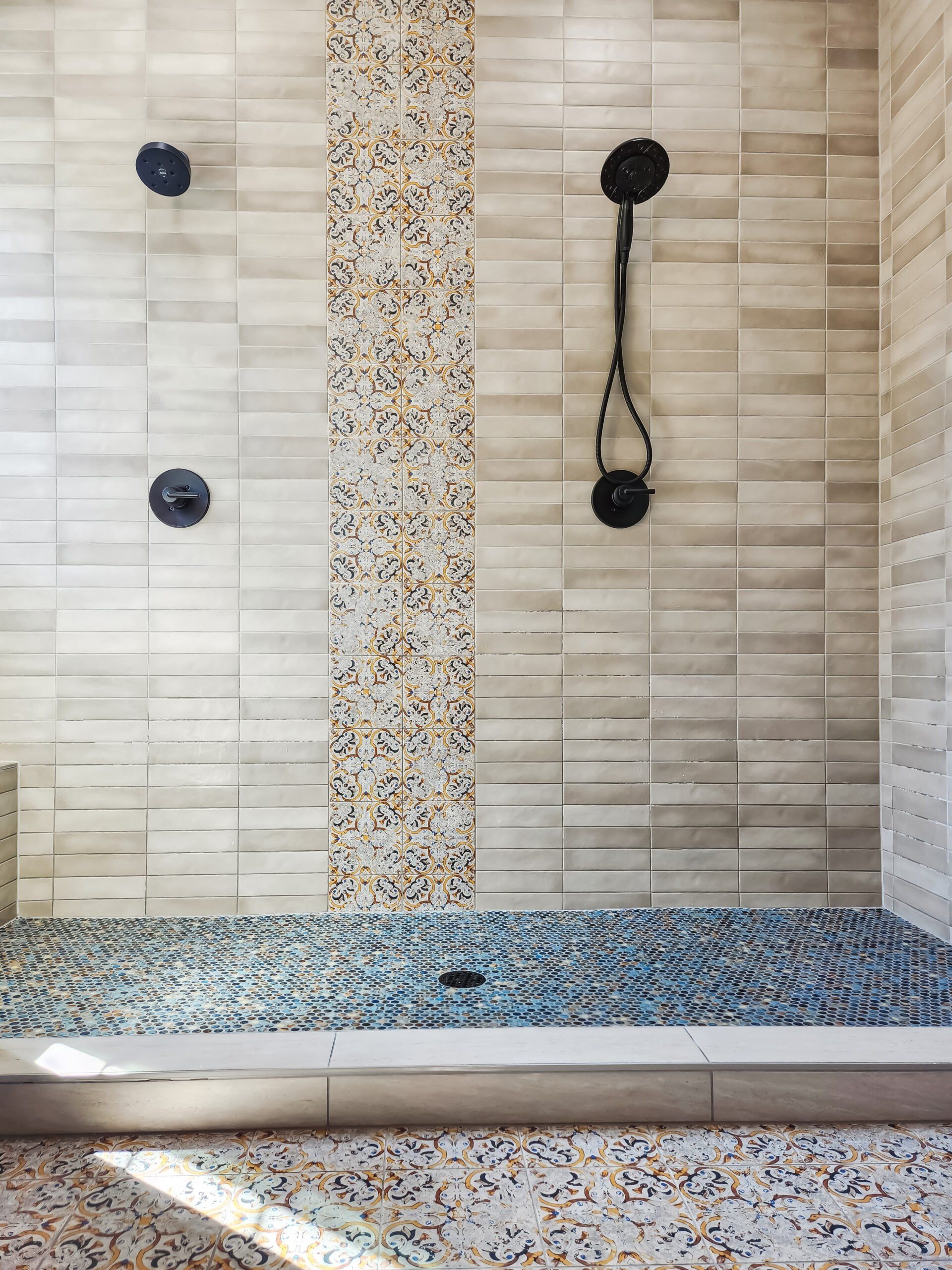 A bathroom with a walk in shower and a mosaic floor.