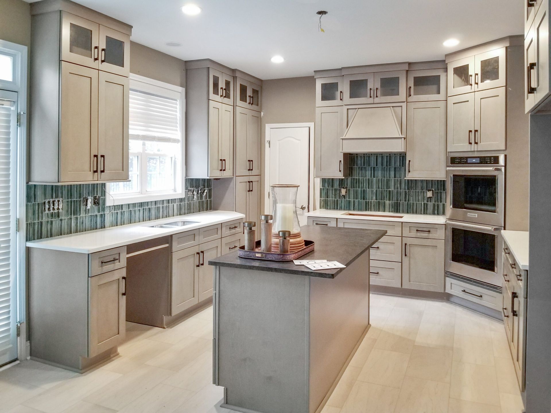 A kitchen with a large island in the middle and stainless steel appliances.