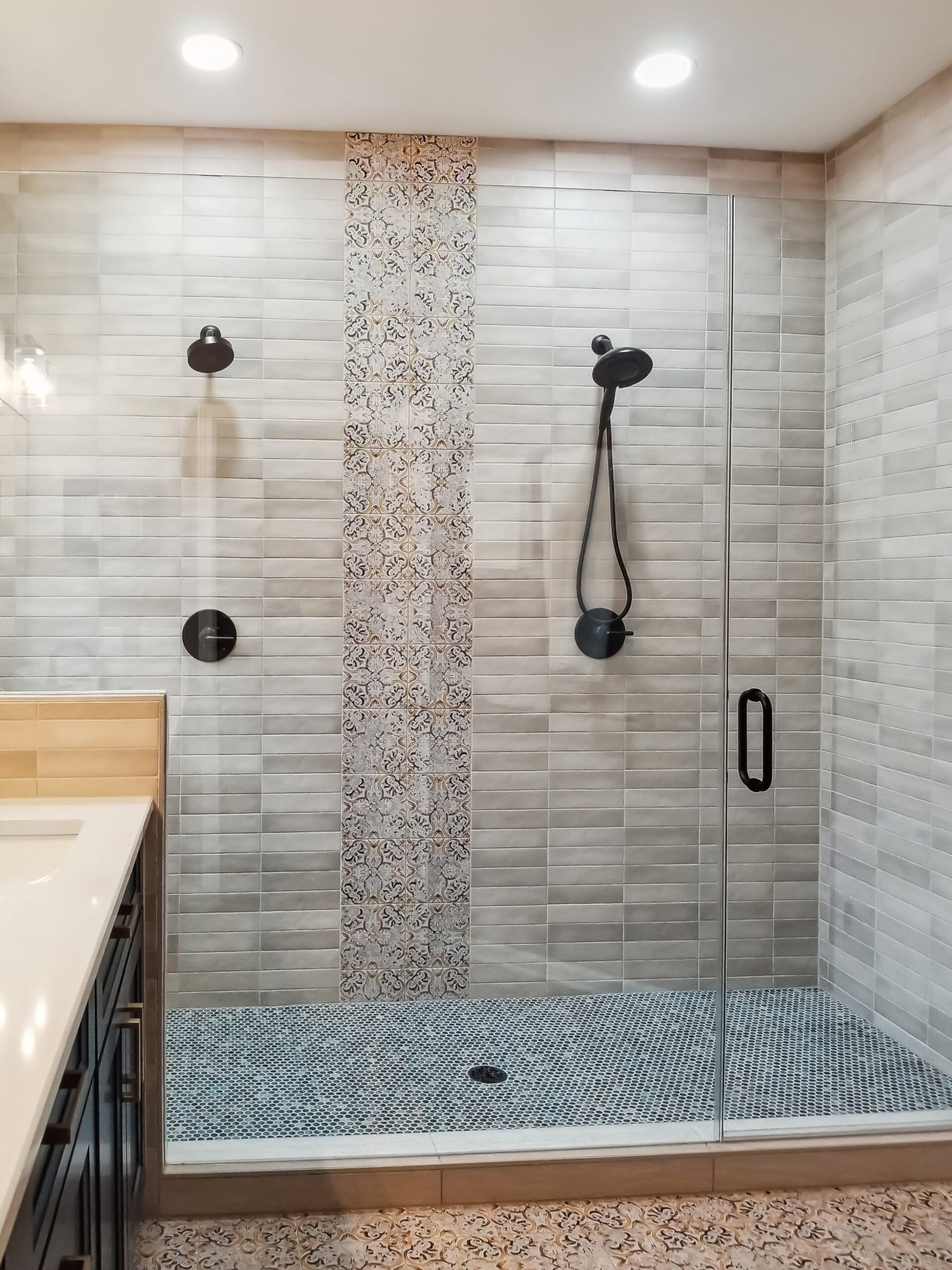 A bathroom with a walk in shower and a sink.