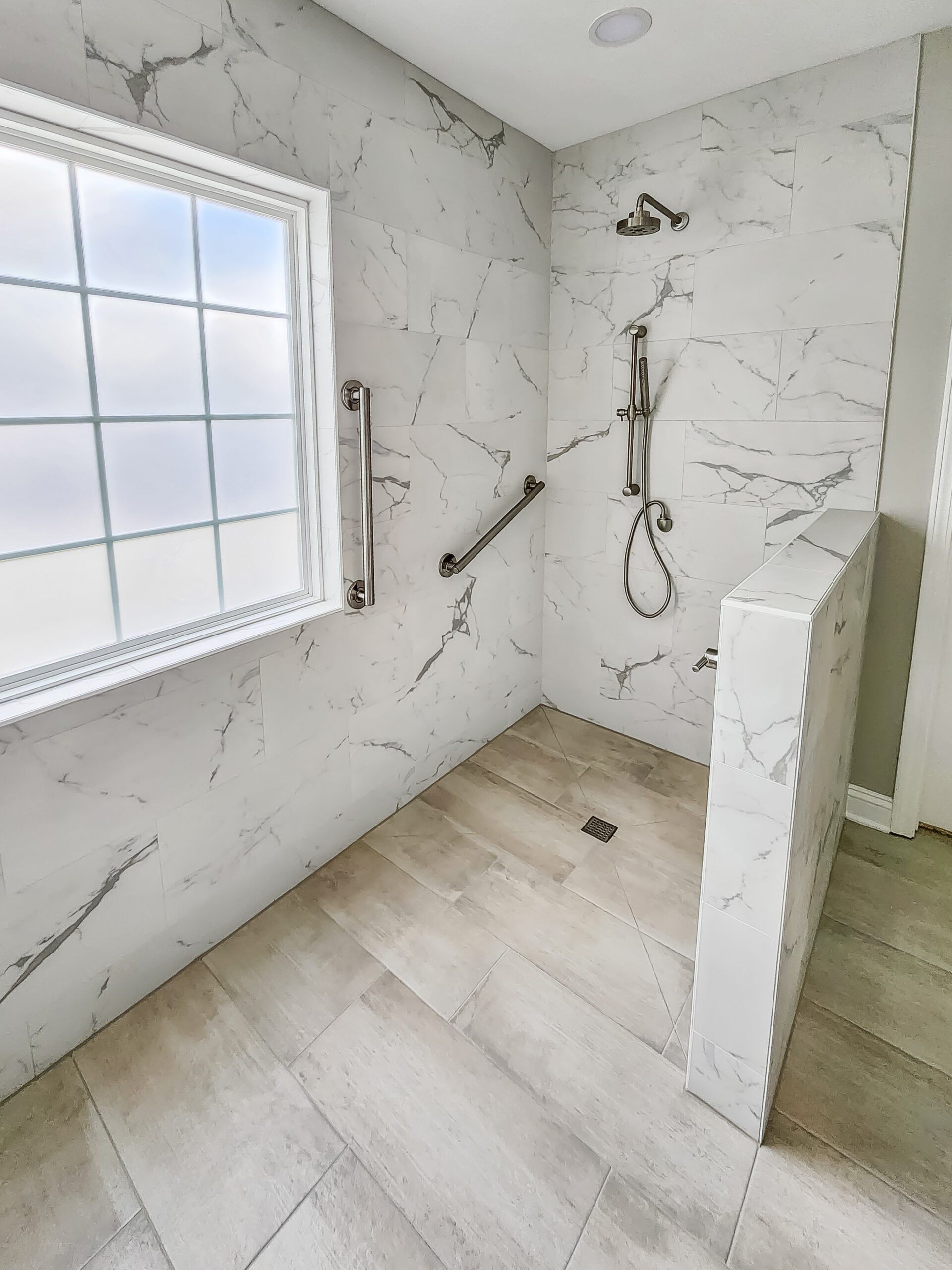 A bathroom with a walk in shower and a window.