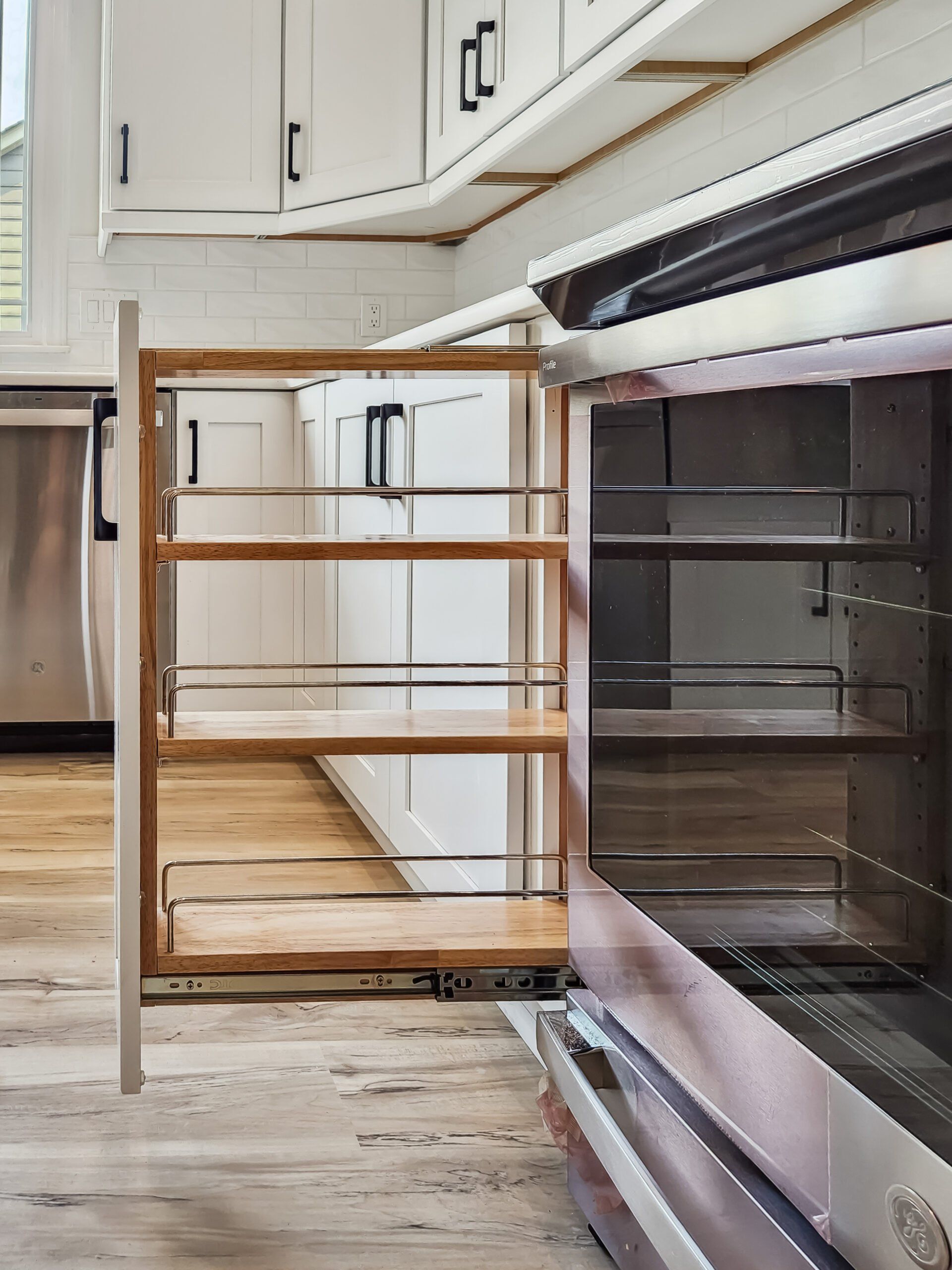 A kitchen with stainless steel appliances and wooden shelves.