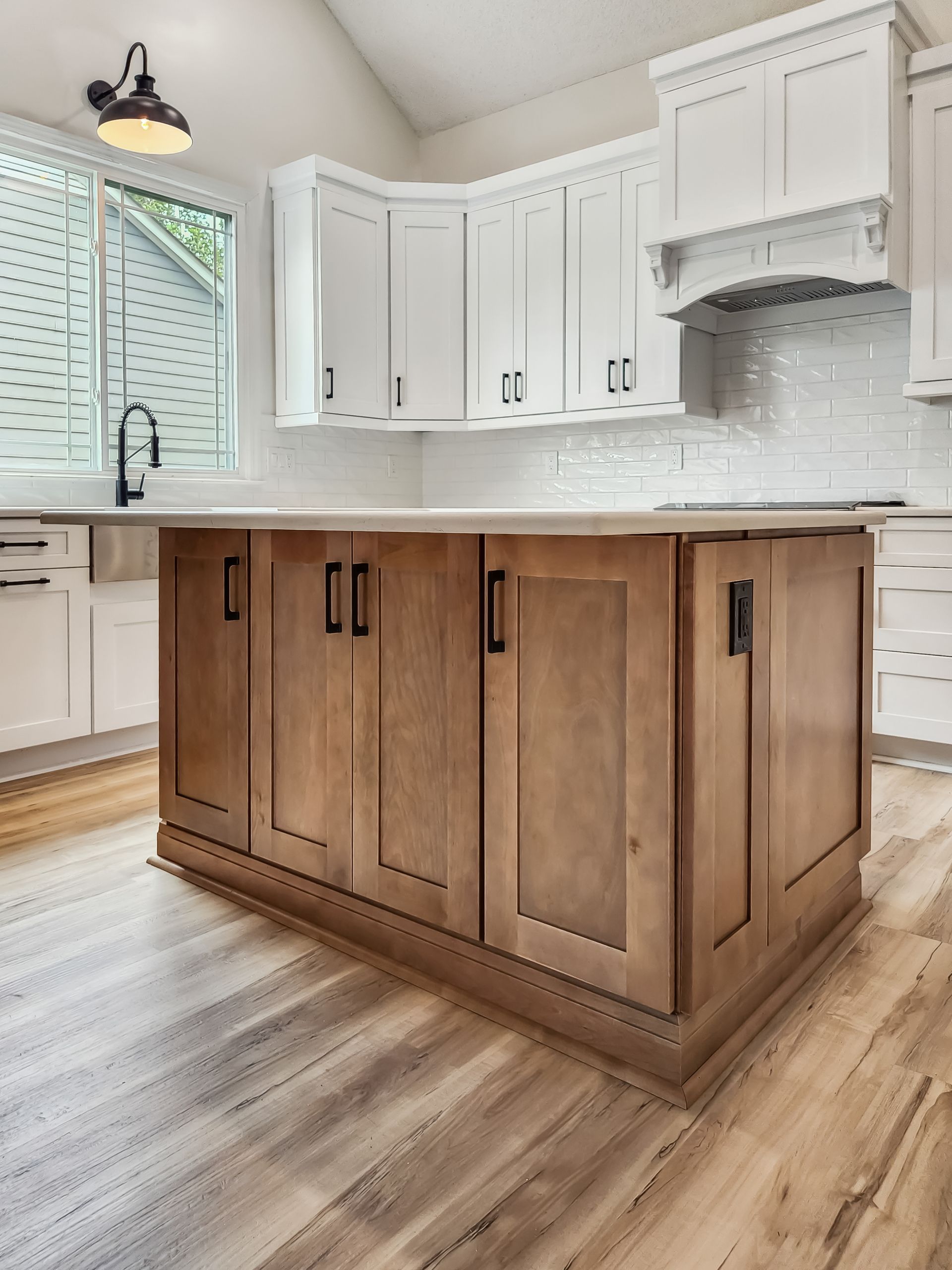 A kitchen with wooden cabinets and a large island in the middle